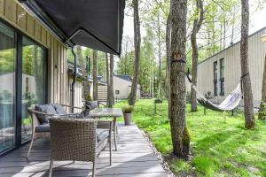 a porch with chairs and a hammock on a house at Stunning Seaside Haus in Palanga