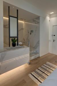 a bathroom with white walls and a window and a rug at Le Palmette Suites in Cagliari