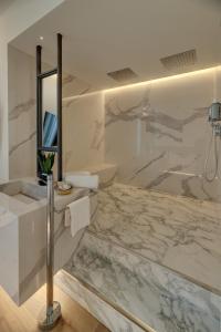 a marble bathroom with a sink and a mirror at Le Palmette Suites in Cagliari