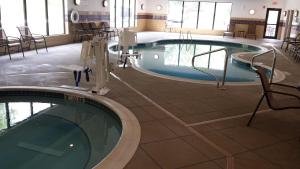 a swimming pool in a building with chairs around it at Holiday Inn Express & Suites Cambridge, an IHG Hotel in Cambridge