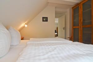 a bedroom with a white bed in a attic at Haus Friedrich-Göhren in Göhren