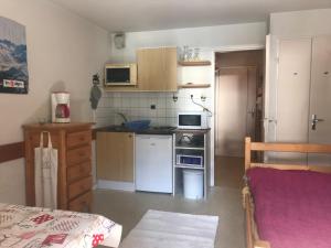 a small kitchen with a stove and a refrigerator at Boost Your Immo Les 2 Alpes Andromede 165 in Vénosc