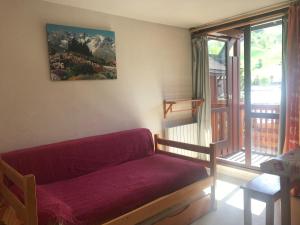 ein Wohnzimmer mit einem roten Sofa und einem Balkon in der Unterkunft Boost Your Immo Les 2 Alpes Andromede 165 in Vénosc