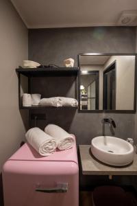 uma casa de banho com uma mala cor-de-rosa e um lavatório em Barbaresco - Wine Loft em Turim