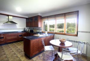 a kitchen with a table and a table and chairs at A Quinta de Lapido in Ortoño