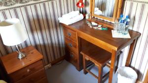 a wooden desk with a mirror and a lamp at Birchdale House B&B in Rathdrum