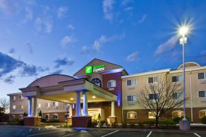 a hotel with a sign on the front of a building at Holiday Inn Express Hotel & Suites Charlotte, an IHG Hotel in Charlotte