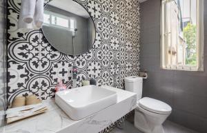 a bathroom with a sink and a toilet and a mirror at Ohana House in Hanoi
