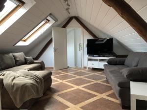 a living room with a couch and a tv at Ferienwohnung auf denkmalgeschütztem Sturmhof in Grefrath