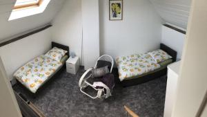 2 bedden en een stoel in een kleine kamer bij Ferienwohnung auf denkmalgeschütztem Sturmhof in Grefrath