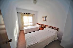 a bedroom with two beds and a window at Apartamento Olimpo Orange Costa in Benicàssim +14 photos