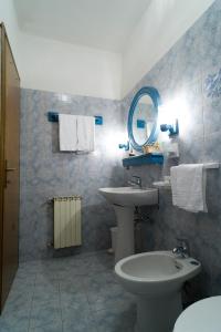 a bathroom with a sink and a toilet and a mirror at Hotel Giardino in Pieve di Cadore