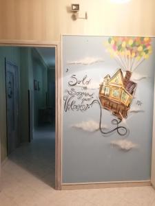 eine Wand mit einem Bild eines Hauses und einem Ballon in der Unterkunft B&B A Casa Dei Nonni in Capua