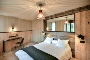 a bedroom with a large bed with a wooden headboard at Logis Hôtel restaurant La Remise in Le Bleymard