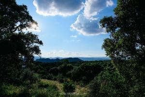 uma vista para um vale com árvores e nuvens em Hotel Barbagia em Dorgali