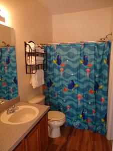 a bathroom with a shower curtain with a toilet and a sink at Orlando Discount Villas - Davenport in Davenport