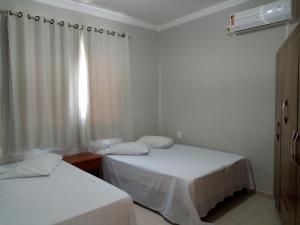 2 camas en una habitación pequeña con ventana en Hospedagem na praia Taperapuan, en Porto Seguro