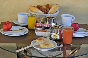 - une table avec des aliments et des boissons pour le petit-déjeuner dans l'établissement Maison des Croisades, à Aigues-Mortes