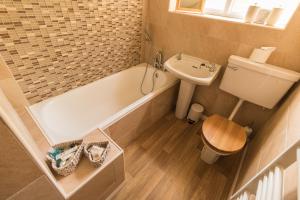 ein Badezimmer mit einer Badewanne, einem WC und einem Waschbecken in der Unterkunft Jasmine Cottage Lastingham North Yorkshire in Pickering