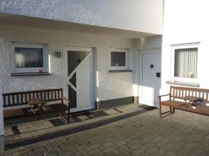 two benches sitting next to a building with a door at Ferienwohnung Erpel in Olpe