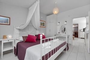 Un dormitorio blanco con una cama y un espejo. en Apartments Villa Joy, en Podgora