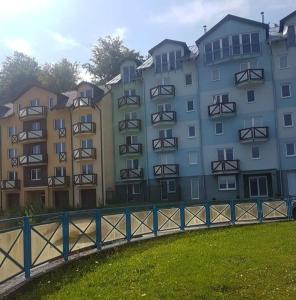 a large building with a fence in front of it at Apartman BibKa in Donovaly