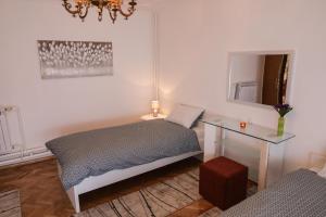 a bedroom with a bed and a table and a mirror at Apartman Kaya in Đakovo