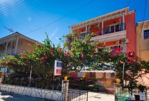 a building with trees and flowers in front of it at Efthalia Apartments & Studios in Nydri