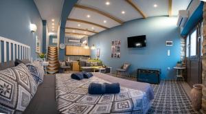 a bedroom with a large bed with blue walls at SaltHouse #1 in Kalabaka