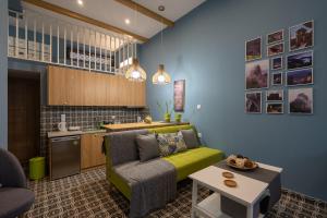 Una sala de estar con un sofá verde y una cocina. en SaltHouse #1, en Kalambaka