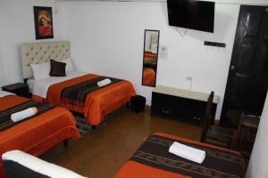 Habitación de hotel con 2 camas y TV de pantalla plana. en Imperial Golden House Inn en Cusco