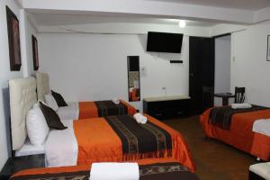Habitación de hotel con 2 camas y TV en Imperial Golden House Inn, en Cusco