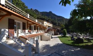 a building with stairs and tables and chairs in a yard at Hotel Arena restaurant le Refuge in Corte