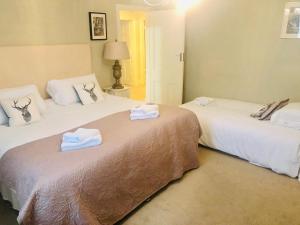 Dos camas en una habitación de hotel con toallas. en Ilkley Central One, en Ilkley