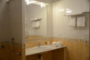 a bathroom with a sink and a mirror and towels at Hotel Arena restaurant le Refuge in Corte