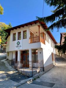 a white building with a balcony on a street at Villa La in Sarajevo