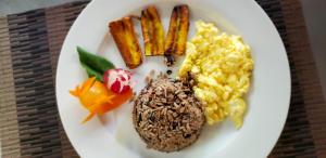 a plate of food with scrambled eggs and carrots at Guacamaya Lodge in Paraíso