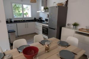 a kitchen with a table with plates on it at Maison Bassin d'Arcachon - Arès - Proche plage et commerces, 3 chambres, 8 personnes, Climatisation in Arès +20 photos