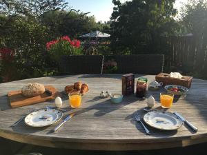 Deil的住宿－Onze Logeerkamer，一张木桌,上面有盘子和餐具