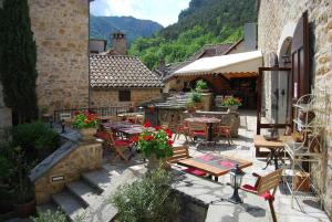 an outdoor patio with tables and chairs in a building at LA GRANGE TEMPLIERE 2018 in Peyreleau