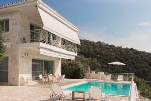 a villa with a swimming pool in front of a house at Meganisi Blue Villa in Meganisi
