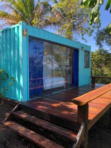 Casa azul con terraza de madera y banco de madera en Fazenda Vista do Mar, en Serra Grande