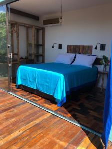 1 dormitorio con cama azul y espejo en Fazenda Vista do Mar, en Serra Grande