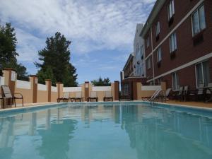 - une grande piscine avec des chaises à côté d'un bâtiment dans l'établissement Holiday Inn Express Hotel & Suites Salisbury - Delmar, an IHG Hotel, à Delmar