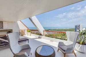 a balcony with chairs and a table and a view of the ocean at Naples Grande Beach Resort in Naples