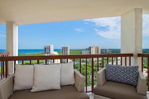 a couch on a balcony with a view of the ocean at Naples Grande Beach Resort in Naples