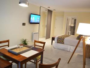 una habitación de hotel con una cama y una mesa y una habitación en SerenaApart en Río Cuarto