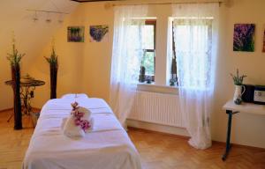 Zimmer mit einem Bett mit weißer Bettwäsche und einem Fenster in der Unterkunft Jagdhof Klein Heilig Kreuz in Großenlüder