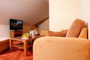 ein Wohnzimmer mit einem Sofa und einem Tisch mit Obst darauf in der Unterkunft Hotel Majolika in Modra