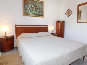 une chambre avec un lit blanc et deux lampes dans l'établissement Sol Nascente Garden, à Vilamoura 28 autres photos